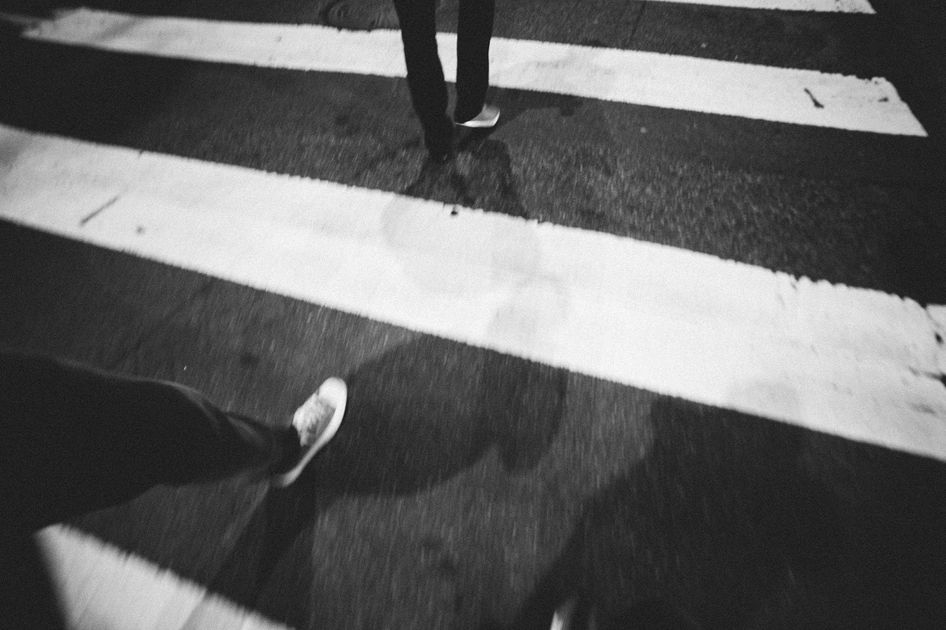 People's Legs Walking on Pedestrian Lane